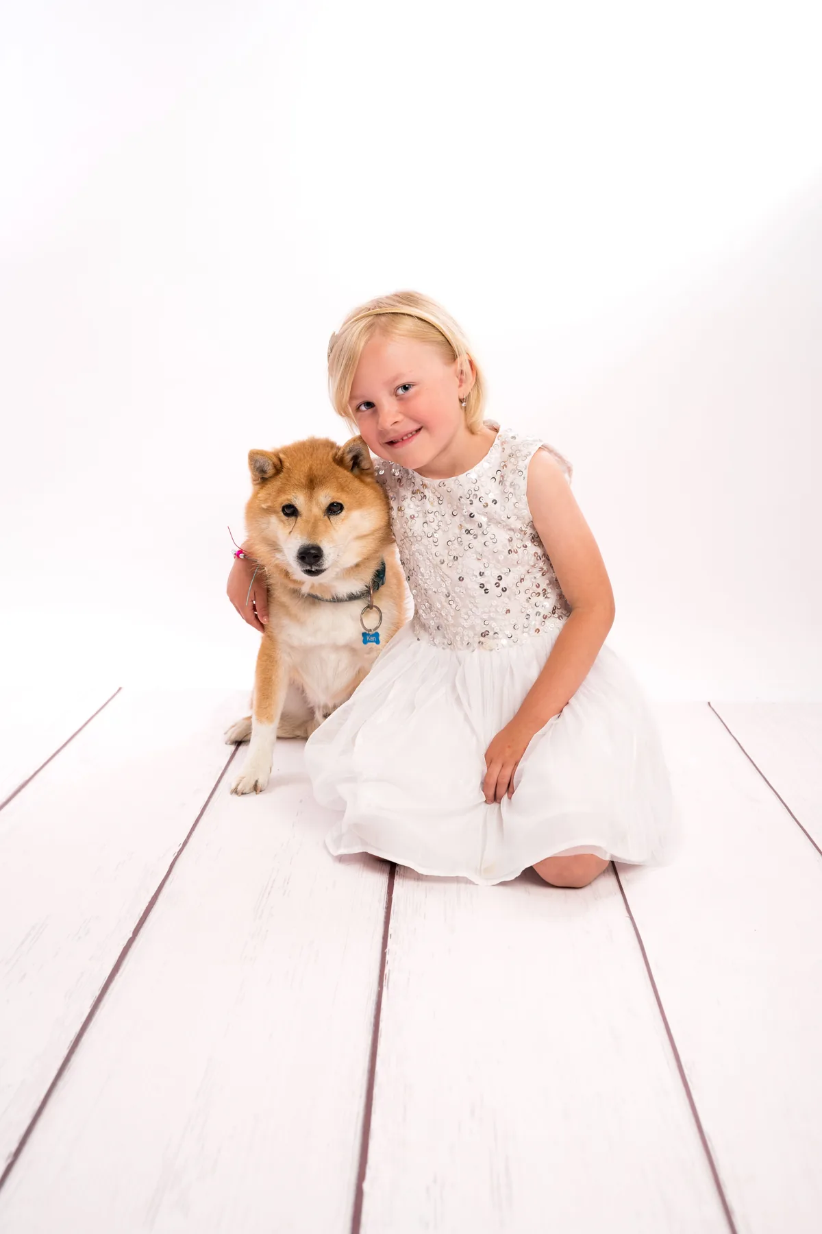 Holčička se shiba-inu v bílém ateliéru